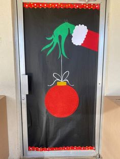 a door decorated with an image of a hand holding a christmas ornament