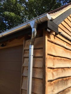 a metal gutter attached to the side of a wooden building