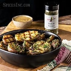 a pan filled with food next to a bottle of wine and some other items on a table