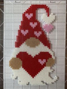 a cross stitch christmas ornament hanging on a wall