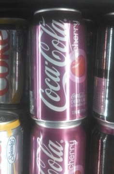 several cans of coca - cola stacked on top of each other