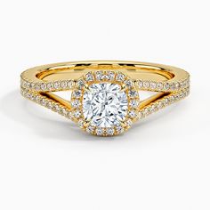 a yellow gold engagement ring with an oval cut diamond surrounded by pave set diamonds