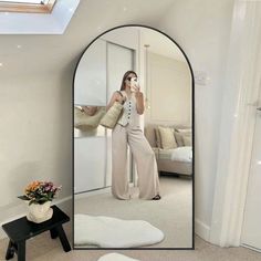 a woman taking a selfie in front of a mirror with her hand on her hip