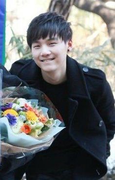 a young man holding a bouquet of flowers