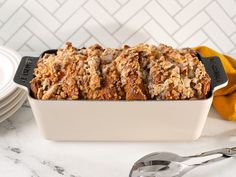 a loaf of bread sitting on top of a counter next to plates and spoons