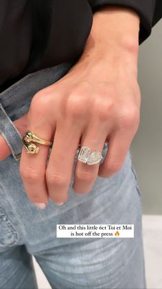 a person wearing a gold ring and jeans