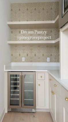 an empty kitchen with white cabinets and silver appliances