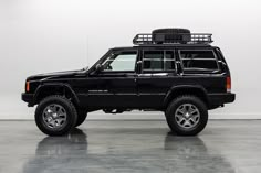 a black jeep is parked in a white room