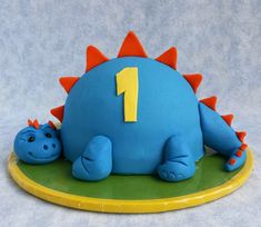 a cake shaped like a dinosaur with the number one on it