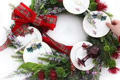 the wreath is decorated with red ribbon and green foliage, while two plates are placed in front of it