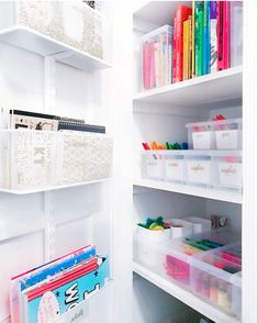 a white shelf filled with lots of books and folders