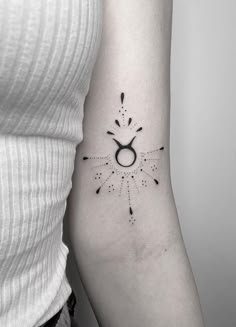 a woman's arm with an astro sign tattoo on it