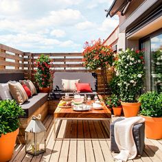 an outdoor patio with potted plants and wooden furniture on the outside decking area