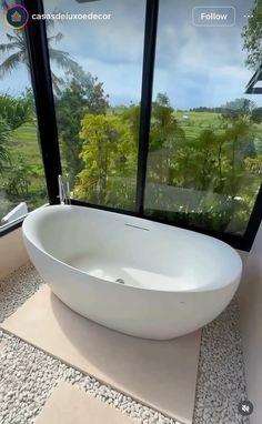 a large white bath tub sitting next to a window