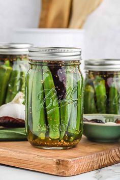 pickled cucumbers in mason jars on a cutting board