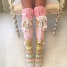 the legs of a woman wearing socks with bows and laces on them, sitting in a chair