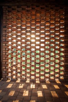 the sun shines through an open window on a brick wall in front of a doorway