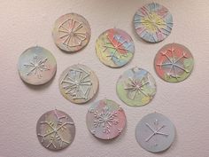 a group of different shapes and sizes of discs on a white wall with paint splatters all over them