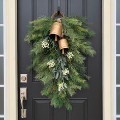 a christmas wreath with bells hanging on the front door