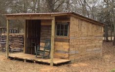 a small wooden shed sitting in the middle of a forest