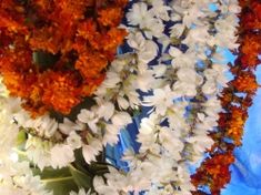 two vases filled with white and orange flowers