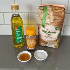 ingredients to make bread sitting on a counter top next to a bag of flour, salt and olive oil