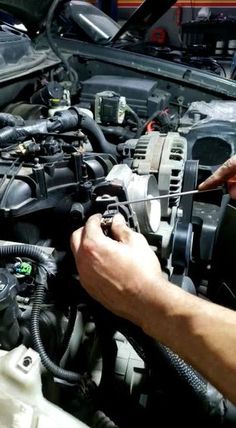 a man working on an engine in his car