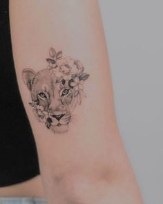 a woman's arm with a tattoo of a lion and flowers on the wrist