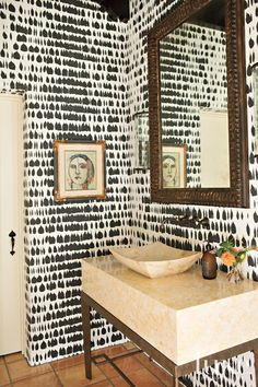 the bathroom is decorated with black and white wallpaper, which has been hand painted