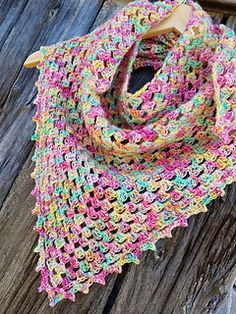 a crocheted scarf sitting on top of a wooden table