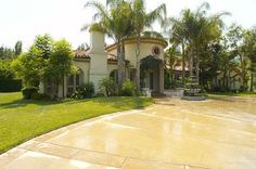 a large house with palm trees in the front yard