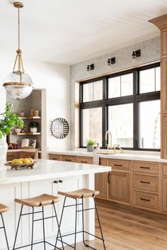 an instagramted photo of a kitchen with lots of counter space and stools