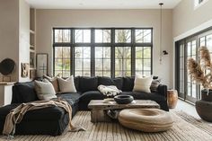 a living room filled with furniture and large windows