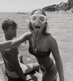 a man and woman in swimsuits on a boat with their mouths wide open