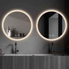 two round mirrors on the wall above a sink