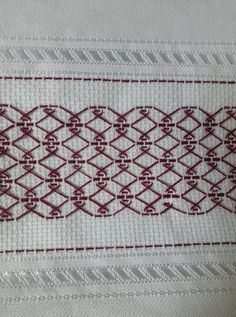 a white and red piece of cloth with some stitching on it