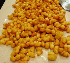 a pile of tater tots sitting on top of a counter next to a spoon