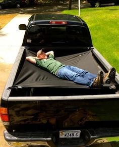 a man laying in the back of a pickup truck