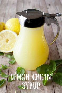 a lemon cream syrup in a glass pitcher next to sliced lemons