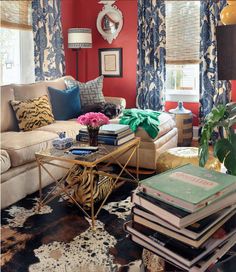 a living room filled with lots of furniture and books on top of a coffee table