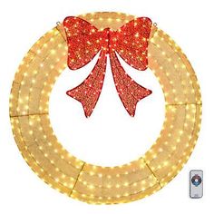 a lighted wreath with a red bow on it