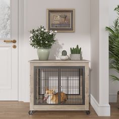 a dog is sitting in its cage next to a potted plant on the table