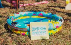 an inflatable swimming pool is on the ground with a sign attached to it