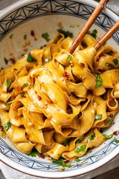 a bowl filled with noodles and chopsticks in it