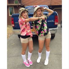 two girls are standing in front of a truck