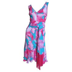 A gorgeous pink and turquoise tropical flower print silk dress with a matching silk fringe wrap/tie belt from Celine. It is sleeveless with a V front and deeper V back, semi fitted through the waist then flares to the hem and comes with a pink silk fringe trim matching tie belt. Beautifully made with finished seams inside, it is unlined and slips on over the head. Because it is cut on the bias it will fit a range of sizes conforming to the wearer. Fits sizes Extra Small, Small, Medium. Marked Fr Silk Yellow Dress, Chocolate Brown Dress, Dvf Wrap Dress, Print Silk Dress, Dress With Fringe, Black Knit Dress, Tropical Flower, Flower Print Dress, Silk Print Dress