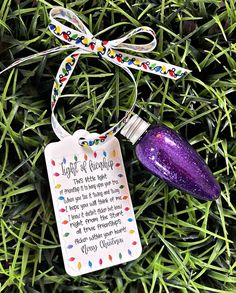 a purple ornament with a poem on it sitting in the grass next to a string