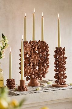 a table topped with candles and vases filled with flowers