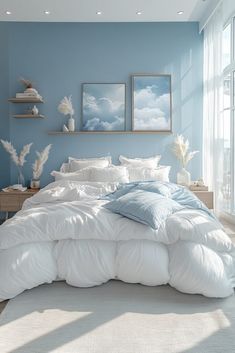 a large bed sitting in a bedroom next to a window covered in white blankets and pillows