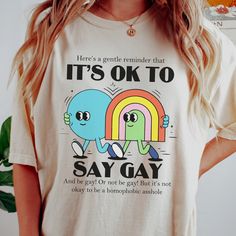 It's Ok to Say Gay T-Shirt, Protect Queer Kids, Don't be Homophobic, Lgbt Ally Shirt, LGBTQ Advocacy Shirt, Comfort Colors Tshirt. Stand up for LGBT Youth with this It's Ok to Say Gay Shirt. Now more than ever, queer kids need to see visible allies. Lets make the world a kinder and safer place for all Queer Youth. SIZING Please size up for the oversized look, refer to the size chart in the final image for the perfect fit. MATERIALS Comfort Colors are the ultimate when it comes to soft and comfor Lgbtq Shirt Design, Lgbtq Tshirt Design, Pride Tshirt Design, Homophobes Getting Owned, Queer Tshirts, Queer Decor, Gender Queer Fashion, Lgbtq Tshirts, Gang Clothes